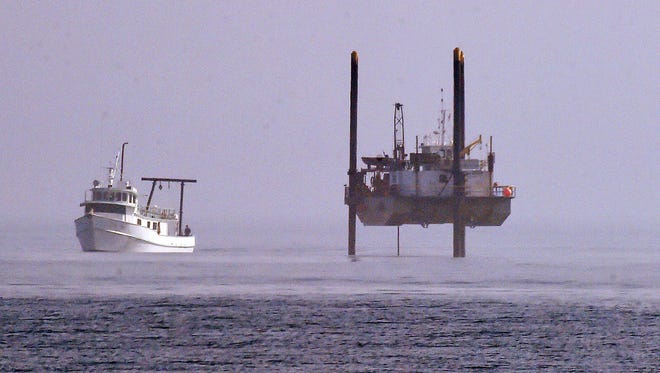 A large offshore drilling rig and survey boat take soil samples from the seabed where the Atlantic Ocean is about 15 feet deep as part of engineering work for the Rehoboth Beach sewage outfall pipe.