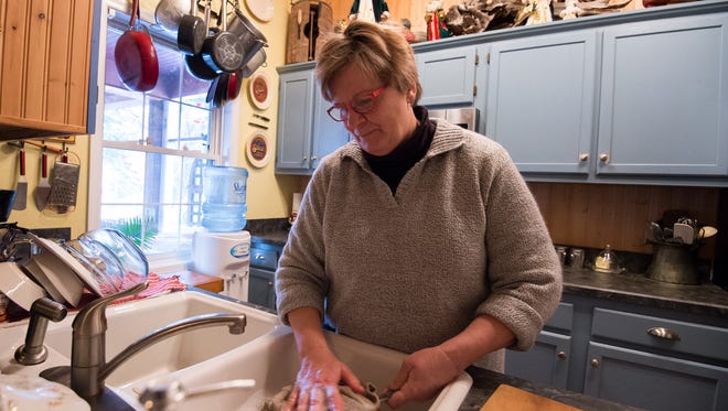 Jean Phillips washes dishes at her home near Millsboro on Tuesday. The home she shares with her husband Bob is one of at least 25 with wells found to contain high nitrate levels linked to pollution from Mountaire Farms' nearby poultry processing plant.